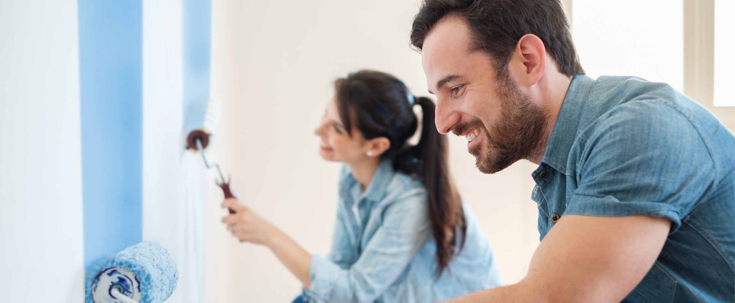 young couple painting the walls of their home