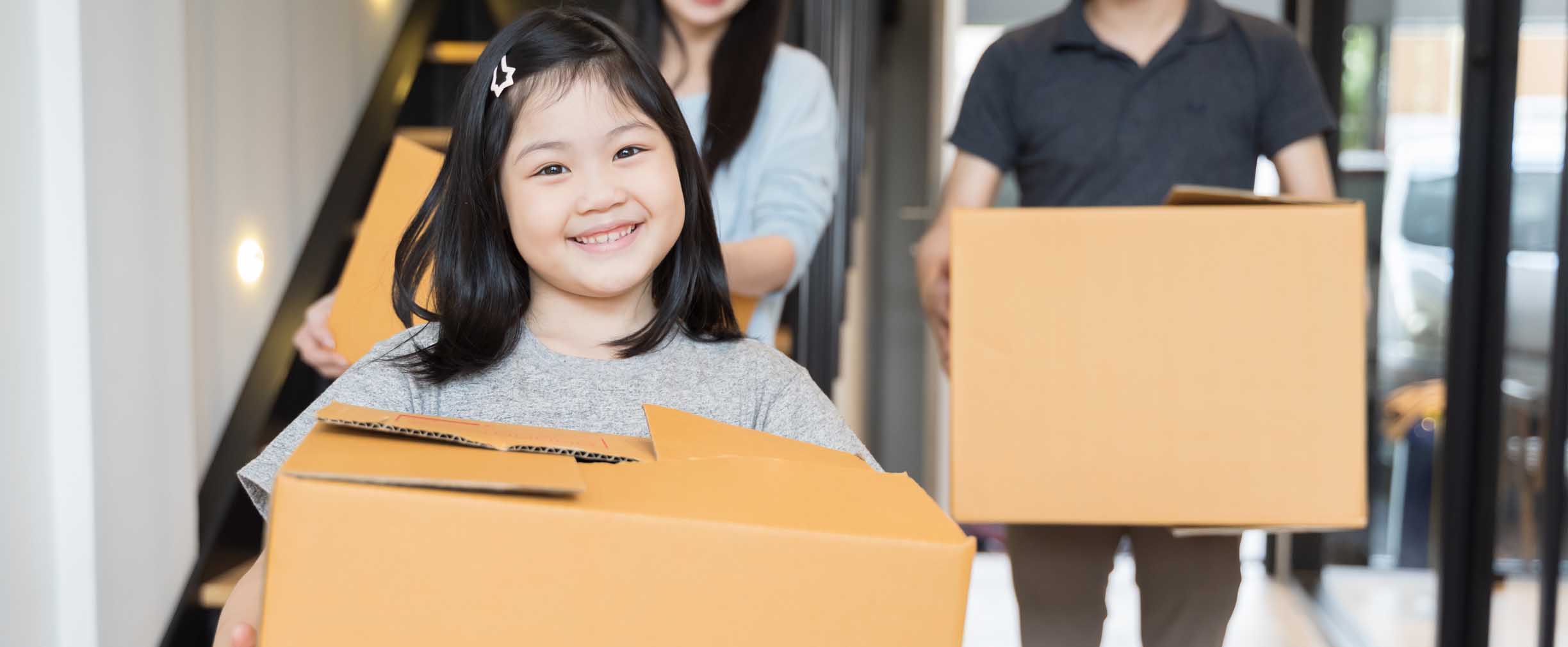 family carrying moving boxes