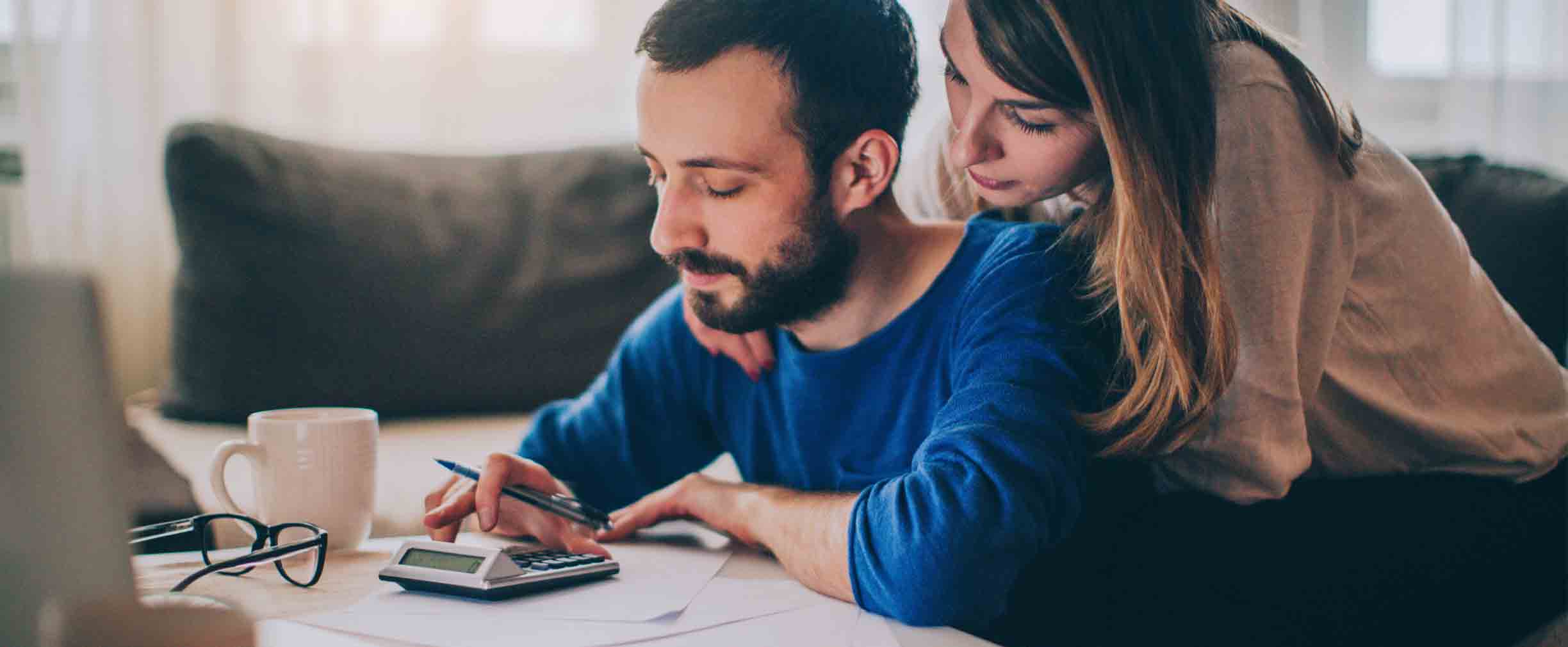 Couple sitting in their living room and checking their finances