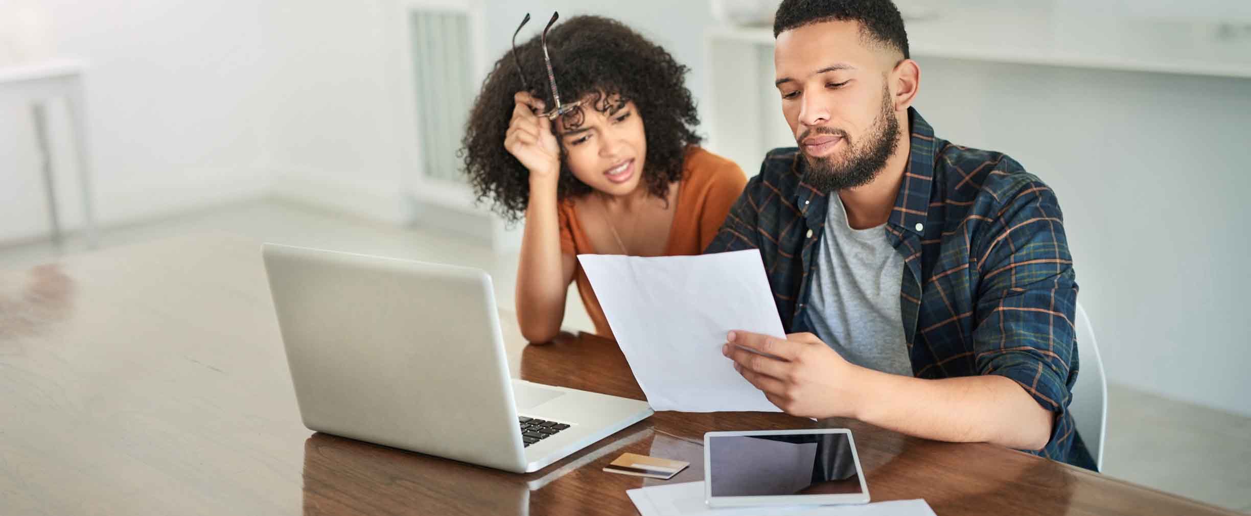 Shot of a young couple looking stressed while going over their finances at home