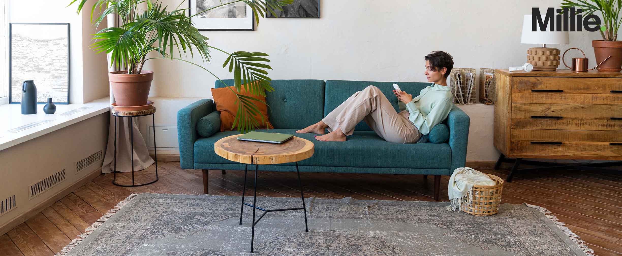 A young woman lounging in a minimalist living room as she uses her phone.