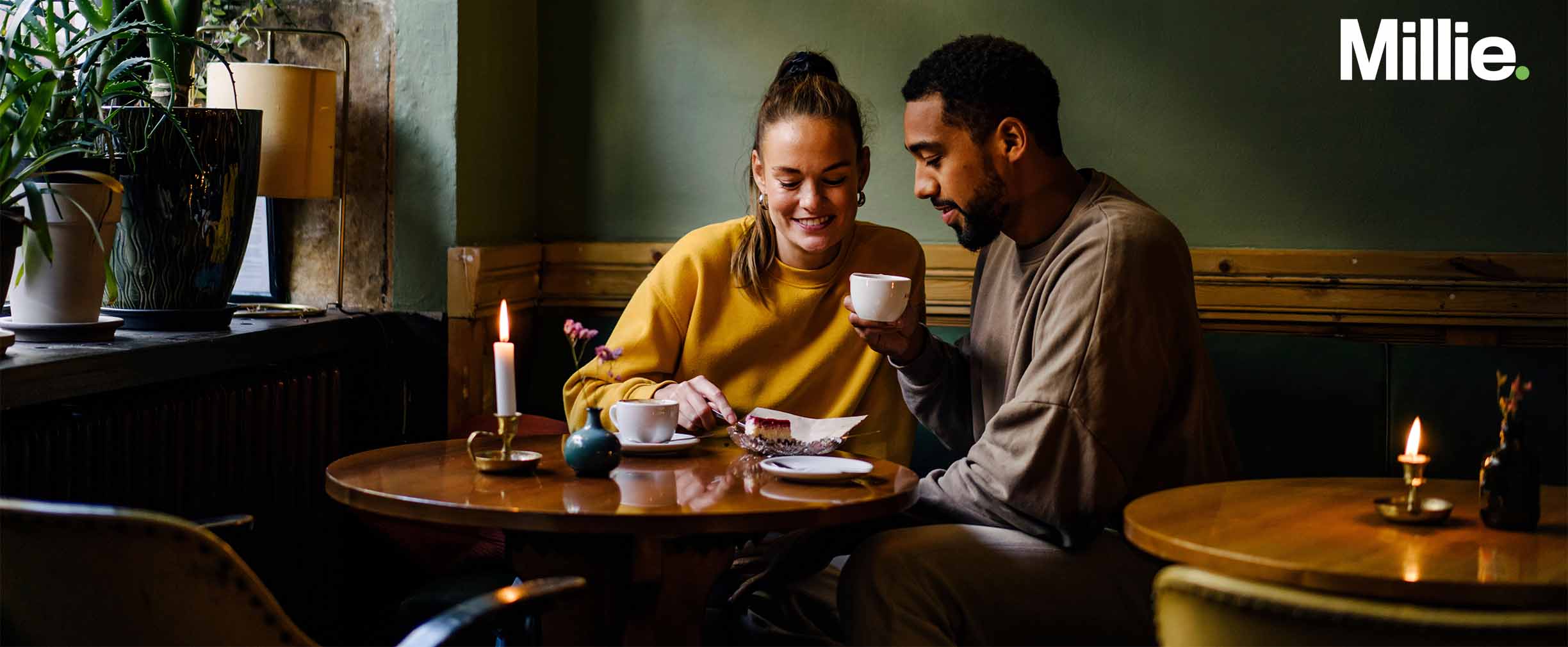 A couple sitting together at a coffee shop, talking intimately. 