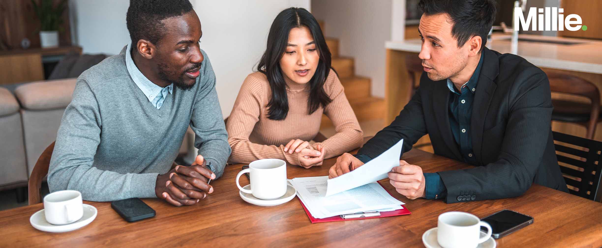 A couple sitting at a table discussing a prenup with a lawyer.