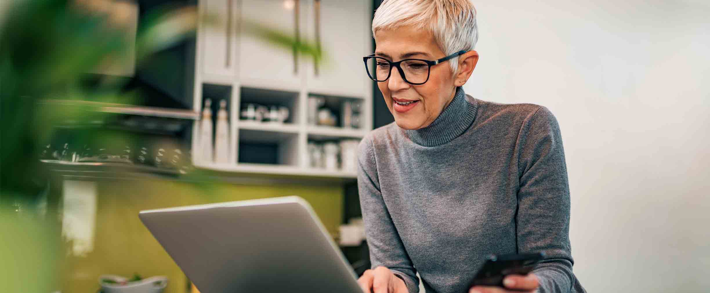 Senior woman sitting at table on computer