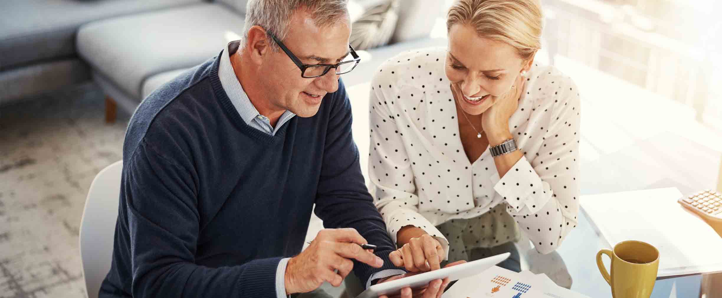 mature couple reviewing their finances on a tablet