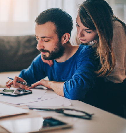 Couple sitting in their living room and checking their finances