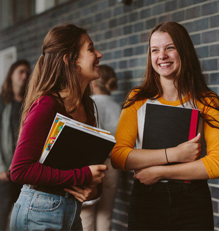 two female students holding books